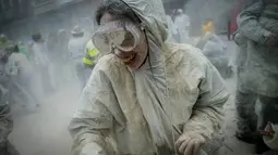 Seorang wanita tubuhnya penuh tepung saat mengikuti festival "Domingo Fareleiro" di desa Xinzo de Limia, Spanyol (21/1). Festival ini juga merupakan ritual pemurnian menjelang masa prapaskah. (AFP/Miguel Riopa)