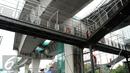 Pekerja menyelesaikan pembangunan jembatan penyeberangan orang jalan layang bus Transjakarta koridor XIII Ciledug-Tendean di kawasan Mayestik Jl. Kyai Maja, Jakarta Selatan, Rabu (2/11). (Liputan6.com/Gempur M. Surya)
