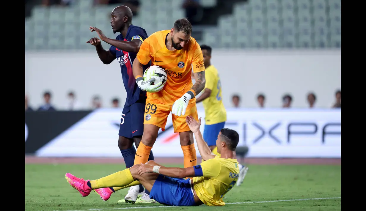 Penjaga gawang PSG, Gianluigi Donnarumma (tengah), membantu berdiri pemain Al Nassr, Cristiano Ronaldo, setelah keduanya berebut bola di udara dalam pertandingan uji coba yang berlangsung di Nagai Stadium, Osaka, Selasa (25/7/2023). (AFP/Paul Miller)