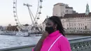 Seorang wanita yang mengenakan masker berjalan di Jembatan Westminster dengan latar pemandangan London Eye di London, Inggris (31/10/2020). Kasus baru COVID-19 di Inggris mencapai 21.915, menambah total kasus coronavirus di negara itu menjadi 1.011.660. (Xinhua/Han Yan)