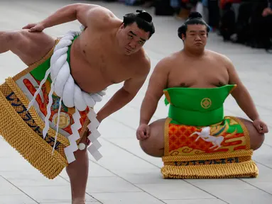 Juara sumo asal mongolia, Yokozuna Hakuho (kiri) melakukan persiapan untuk ritual tahunan di Kuil Meiji di Tokyo, Jepang, (7/1). Ritual ini dalam perayaan tahun baru 2016. (REUTERS / Yuya Shino)