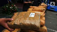 Tumpukan ganja dihadirkan saat pemusnahan barang bukti di Lapangan Gedung BNN, Jakarta, Rabu (18/1/2023). BNN memusnahkan barang bukti 222,697 kilogram ganja dan menangkap empat tersangka berinisial AE alias Adul, RJ, MF, dan G yang merupakan narapidana Lapas Kelas I Tangerang dari pengiriman paket kargo di depan Mall Cijantung. (merdeka.com/Imam Buhori)