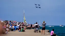 Pengunjung menyaksikan US Navy Blue Angels tampil pada Chicago Air and Water Show di atas Danau Michigan, Chicago, Amerika Serikat, 21 Agustus 2022. Chicago Air and Water Show diadakan setiap tahun sejak 1959. (AP Photo/Kiichiro Sato)