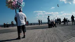 Orang-orang menikmati hari di Coney Island, salah satu tujuan pantai paling populer di wilayah Brooklyn di New York City (29/6/2022). Kota New York menghadapi kekurangan penjaga pantai di kolam renang kota dan pantai tahun ini, memaksa beberapa daerah untuk membatasi waktu berenang. (Spencer Platt/Getty Images/AFP)