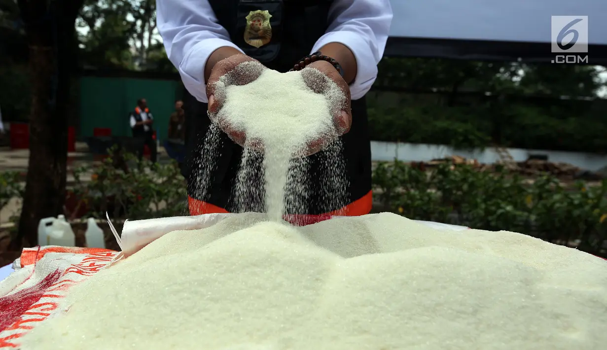 Petugas menunjukan gula kristal yang sudah kedaluwarsa hasil sitaan di Kemendag, Jakarta Kamis (28/9). Petugas dari Kemendag berhasil menyita sebanyak 21,3 ton Gula Kristal dan 47,9 ton daging beku kedaluwarsa. (Liputan6.com/JohanTallo)