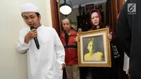 Pelayat membawa foto alm RMH Heroe Siswanto NS atau dikenal Sys NS di rumah duka, Jakarta, Selasa (23/1). Sys NS wafat diusia 61 tahun akibat serangan jantung. (Liputan6.com/Helmi Fithriansyah)