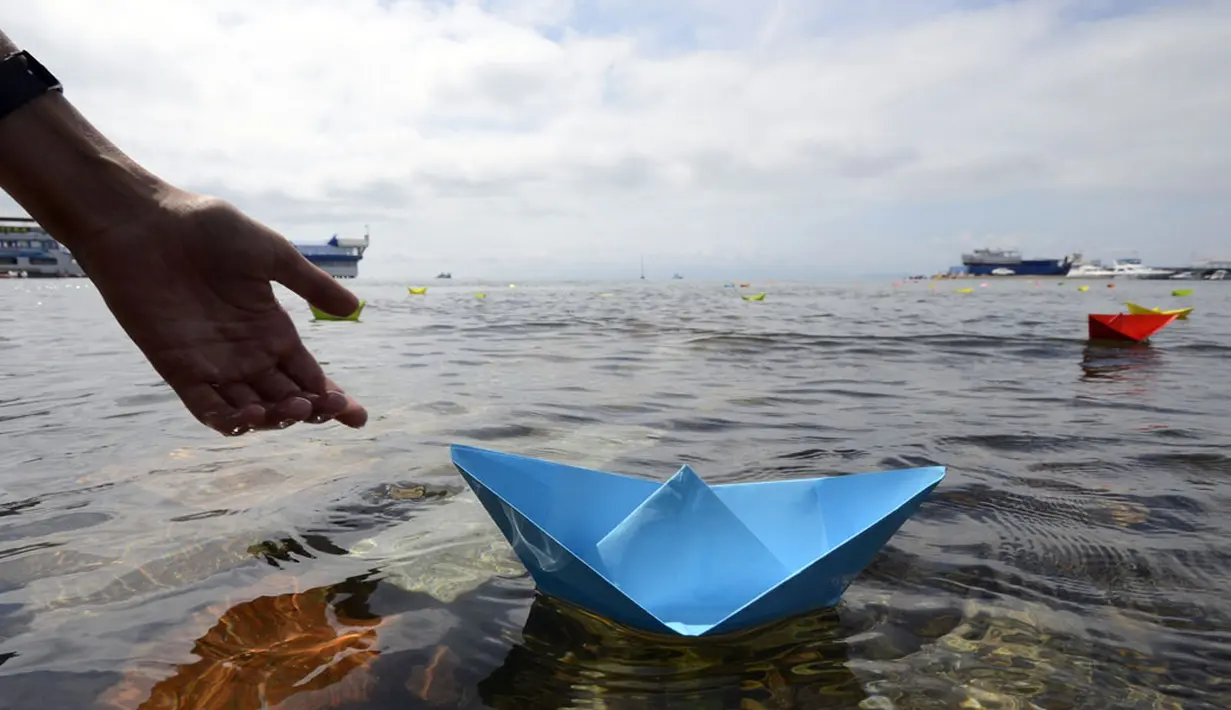 Seorang warga meluncurkan perahu kertas saat perayaan 69 tahun akhir Perang Dunia II di Timur Jauh Vladivostok, Rusia, (2/9/2014). (REUTERS/Yuri Maltsev)