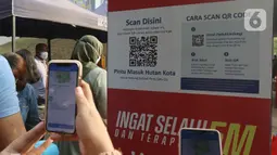 Warga melakukan scan QR code melalui aplikasi PeduliLindungi di Hutan Kota Gelora Bung Karno (GBK), Jakarta, Minggu (17/10/2021). Hutan Kota mulai dibuka secara umum dengan memberlakukan pembatasan sebanyak 150 orang dengan batas waktu satu jam kunjungan. (Liputan6.com/Herman Zakharia)