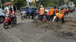 Pekerja membongkar aspal untuk melakukan perawatan rutin rel kereta api di Manggarai, Jakarta, Selasa (11/7). Perawatan rutin rel kereta api tersebut dilakukan secara berkala guna menjamin keselamatan dan kenyamanan masyarakat. (Liputan6.com/Helmi Afandi)