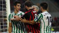 Striker AC Milan, Gonzalo Higuain, bersitegang dengan pemain Real Betis, Aissa Mandi, pada laga Liga Europa di Stadion San Siro, Kamis (25/10/2018). AC Milan takluk 1-2 dari Real Betis. (AP/Antonio Calanni)
