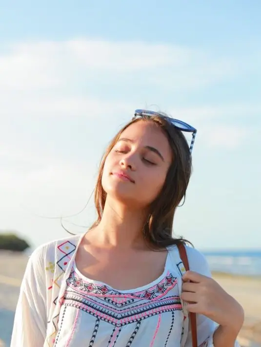 Menikmati liburannya di Sumba, Aurora tampil menggunakan baju warna puith bercorak. Dengan kacamata yang ditarik ke atas rambutnya dan cahaya matahari menerpa wajahnya, ia terlihat sangat menikmati suasana pantai. (Liputan6.com/IG/@auroraribero)
