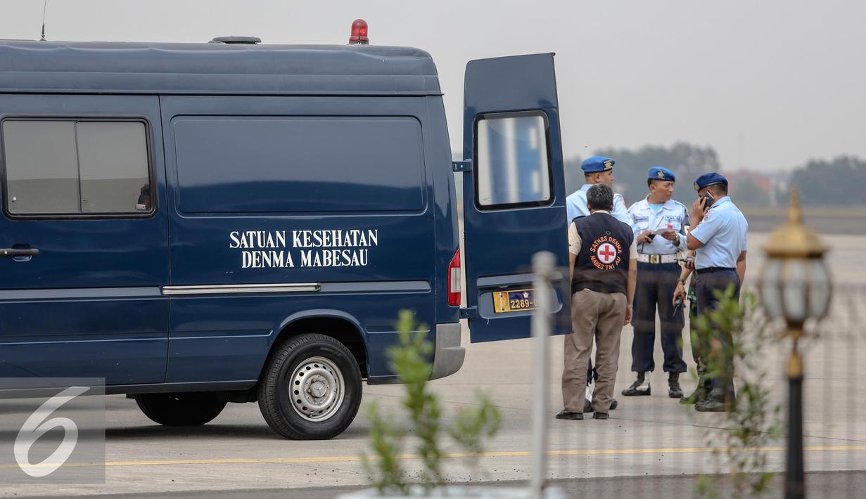 Petugas TNI AU berjaga di belakang mobil menunggu kedatangan jenazah korban jatuhnya Pesawat Hercules C-130 yang akan tiba di Lanud Halim, Jakarta, Rabu (1/7/2015). Peristiwa nahas tersebut merenggut sekitar 122 korban jiwa. (Liputan6.com/Faizal Fanani)