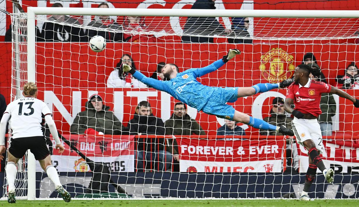Kiper Manchester United, David de Gea, berusaha menghalau bola saat melawan Fulham pada laga Liga Inggris di Stadion Old Trafford (19/3/2023). (AFP/Paul Ellis)