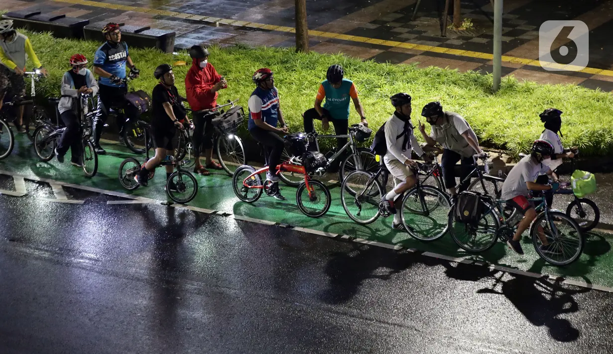 Pegiat bersepeda dan aktivis pecinta lingkungan jelang aksi gowes Kelap Kelip Jakarta Night Ride #NOP26, Jalan Jenderal Sudirman, Jakarta, Jumat (26/11/2021). Aksi ini mendorong pemimpin dunia berkomitmen meningkatkan tingkat bersepeda untuk mengurangi emisi karbon. (Liputan6.com/Helmi Fithriansyah)