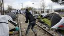 Seorang imigran melempar batu ke arah polisi Makedonia di Desa Idomeni, Yunani (28/11/2015). (REUTERS/Yannis Behrakis)