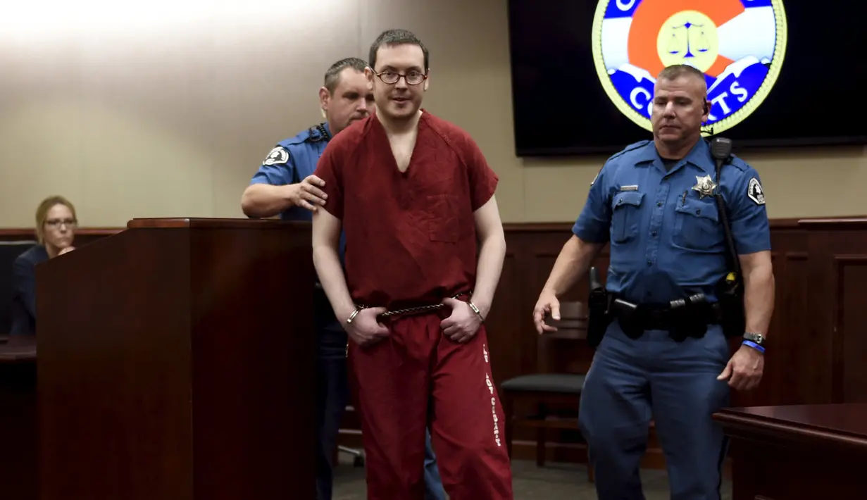 Terdakwa penembak di bioskop Colorado, James Holmes dikawal petugas usai mengikuti sidang di Centennial, Colorado, Rabu (26/8/2015). James dijatuhi hukuman penjara seumur hidup tanpa pembebasan bersyarat atas pembunuhan 12 orang.(REUTERS/RJ Sangosti/Pool)