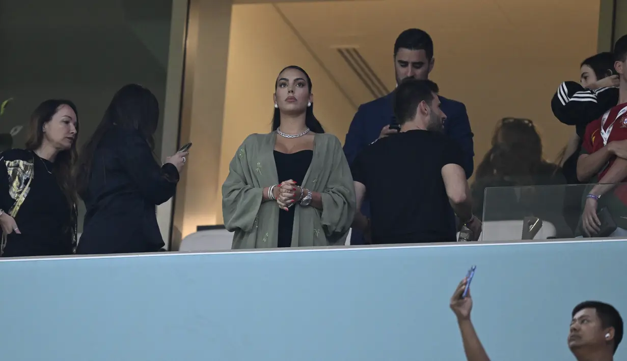 Georgina Rodriguez  menghadiri pertandingan babak 16 besar Piala Dunia Qatar 2022 antara Portugal dan Swiss di Stadion Lusail di Lusail, utara Doha (6/12/2022). Georgina Rodriguez  tampil mengenakan gaun strapless hitam saat berada di tribun penonton. (AFP/Patricia De Melo Moreira)