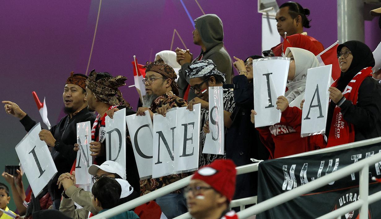 Sekelompok suporter Indonesia saat mendukung Timnas Indonesia menghadapi Vietnam pada laga kedua Grup D Piala Asia 2023 di Abdullah Bin Khalifa Stadium, Doha, Qatar, Jumat (19/1/2024). (AFP/Karim Jaafar)