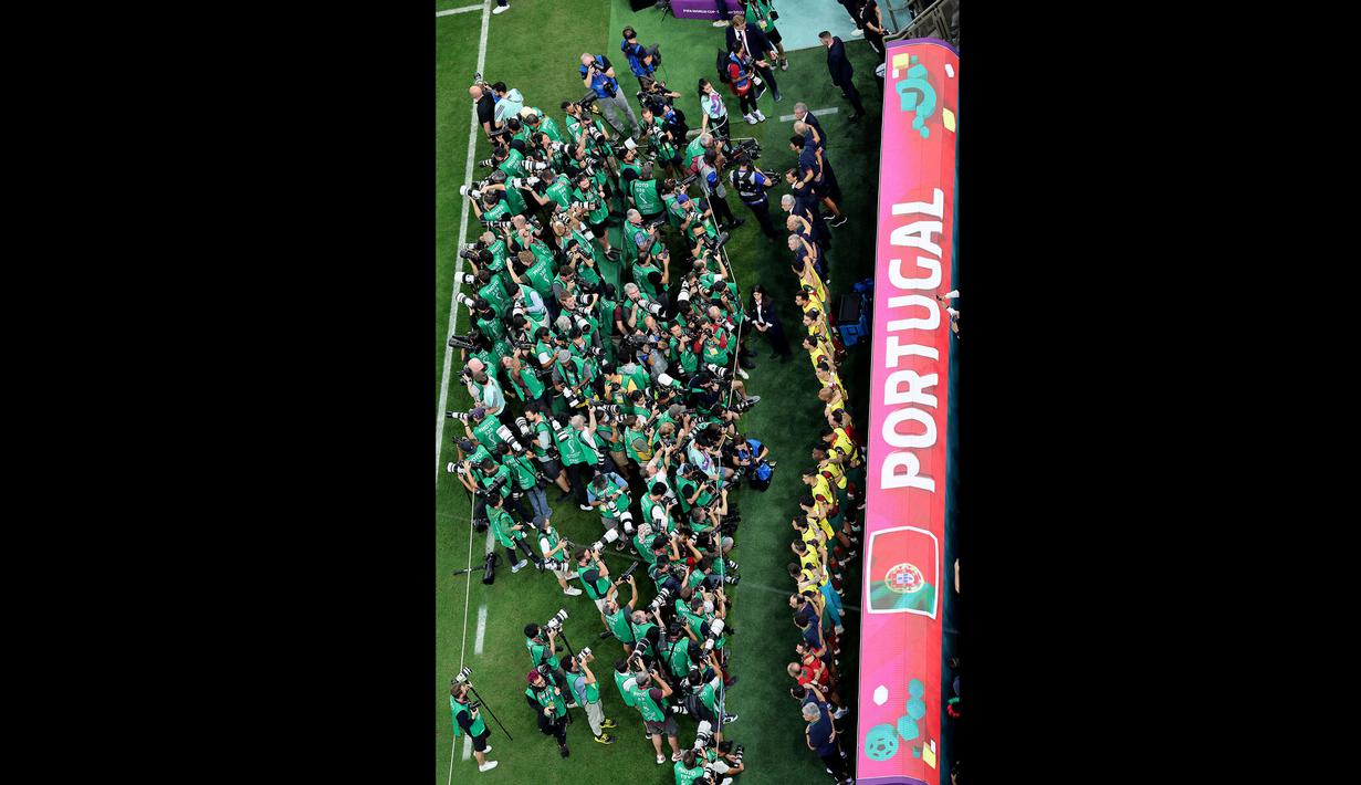 Para fotografer yang biasanya berlomba-lomba mencari momen para pemain starter yang ada didepannya malah lebih memilih berbalik arah memotret deretan para pemain cadangan yang di dalamnya ada Cristiano Ronaldo. (AFP/Giuseppe Cacace)