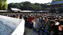 Warga memanjatkan doa Tahun Baru 2018 di Kuil Meiji, Tokyo, Jepang (1/1). Jutaan warga Jepang mengunjungi kuil-kuil di seluruh negeri selama tiga hari pertama tahun baru untuk berdoa demi kesejahteraan keluarga mereka. (AFP Photo/Kazuhiro Nogi)