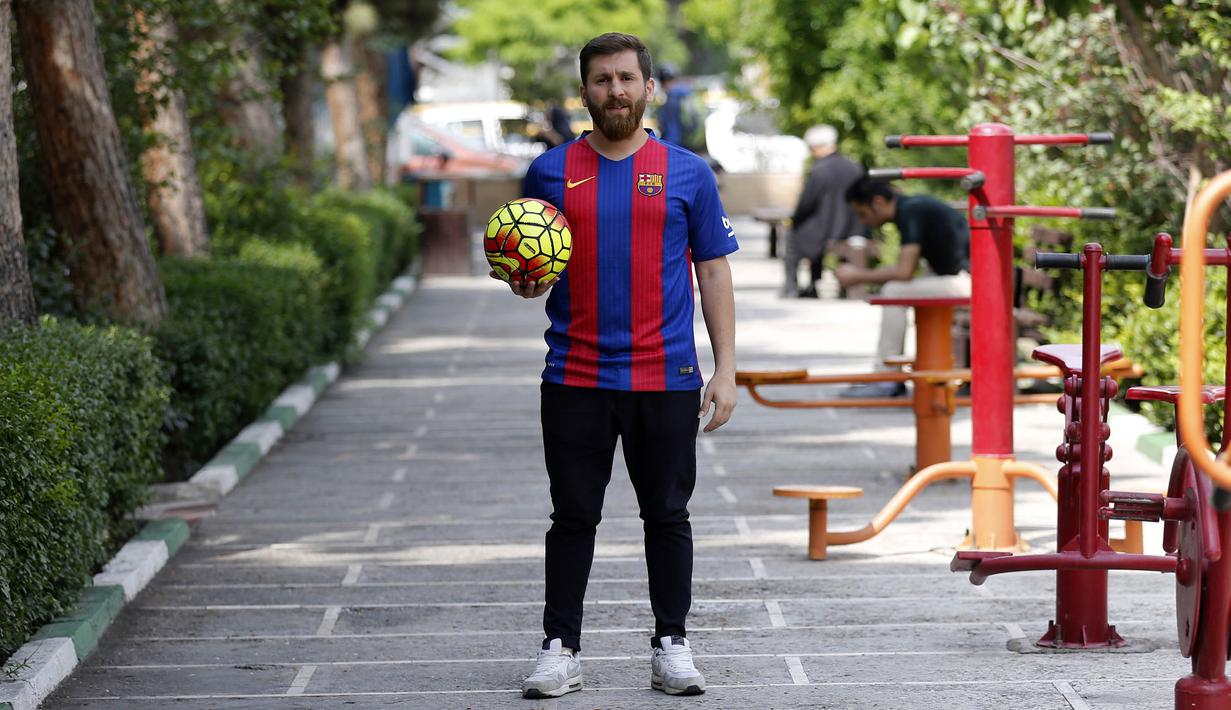 Reza Parastesh, seorang warga Iran yang memiliki wajah mirip Lionel Messi berpose saat jalan-jalan di jalanan Tehran, Iran, Senin (8/5/2017). (AFP/Atta Kenare)