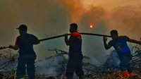 Petugas gabungan TNI, Polda Riau dan BPBD memadamkan kebakaran lahan di Pekanbaru beberapa waktu lalu. (Liputan6.com/M Syukur)