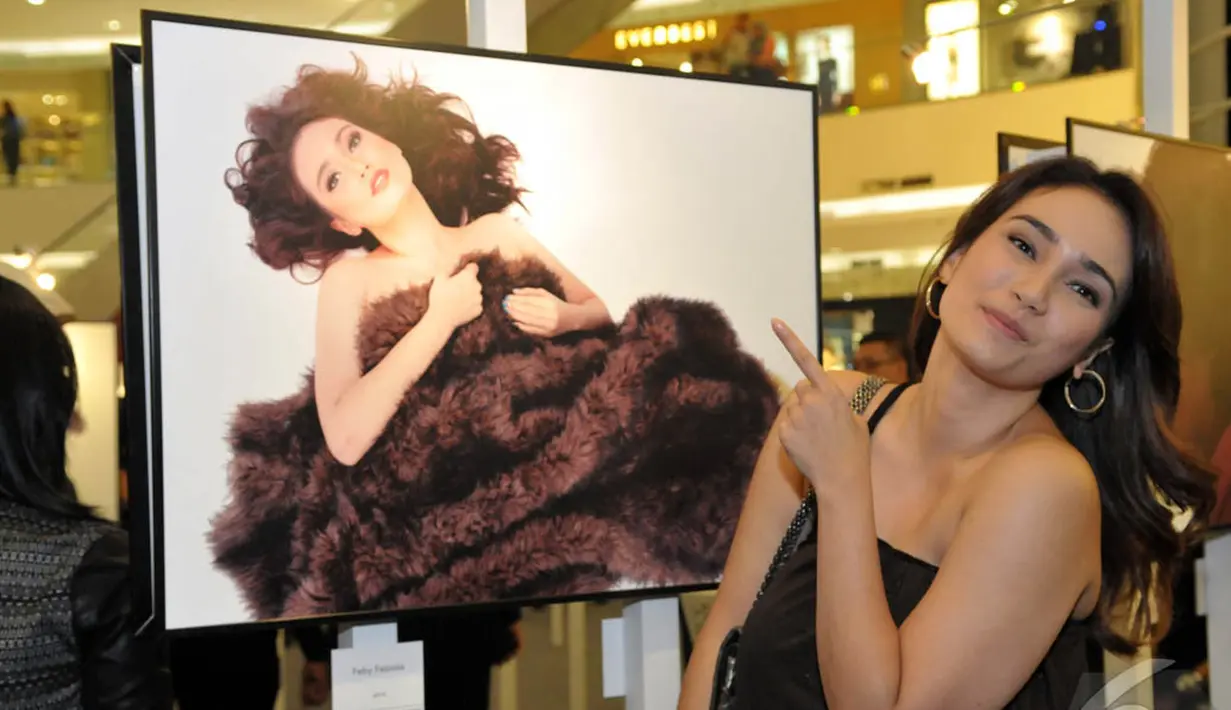 Feby Febiola narsis di samping foto dirinya saat hadiri pameran tunggal Jerry Aurum, Senayan City, Jakarta, Rabu (17/9/2014) (Liputan6.com/Panji Diksana)