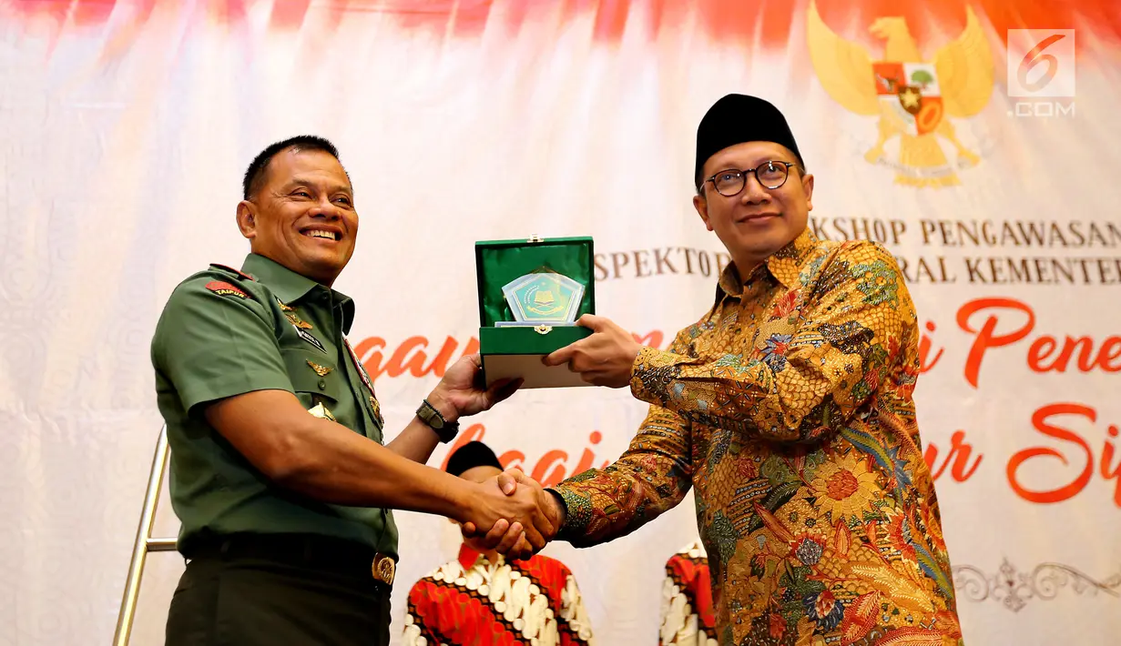 Panglima TNI Jenderal Gatot Nurmantyo menerima plakat dari Menag Lukman Hakim Saifuddin pada acara Workshop Pengawasan Inspektorat Jenderal Kemenag di Jakarta, Rabu (31/05). (Liputan6.com/Fery Pradolo)