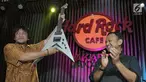 Pemenang lelang diwakili Eddy Gun (kiri) menerima gitar milik band Megadeth yang dilelang dalam acara di Jakarta, Jumat (30/11). Gitar yang dilelang untuk membantu korban gempa di Palu dan Donggala itu terjual seharga Rp150 juta. (New Fimela/Bambang Eros)