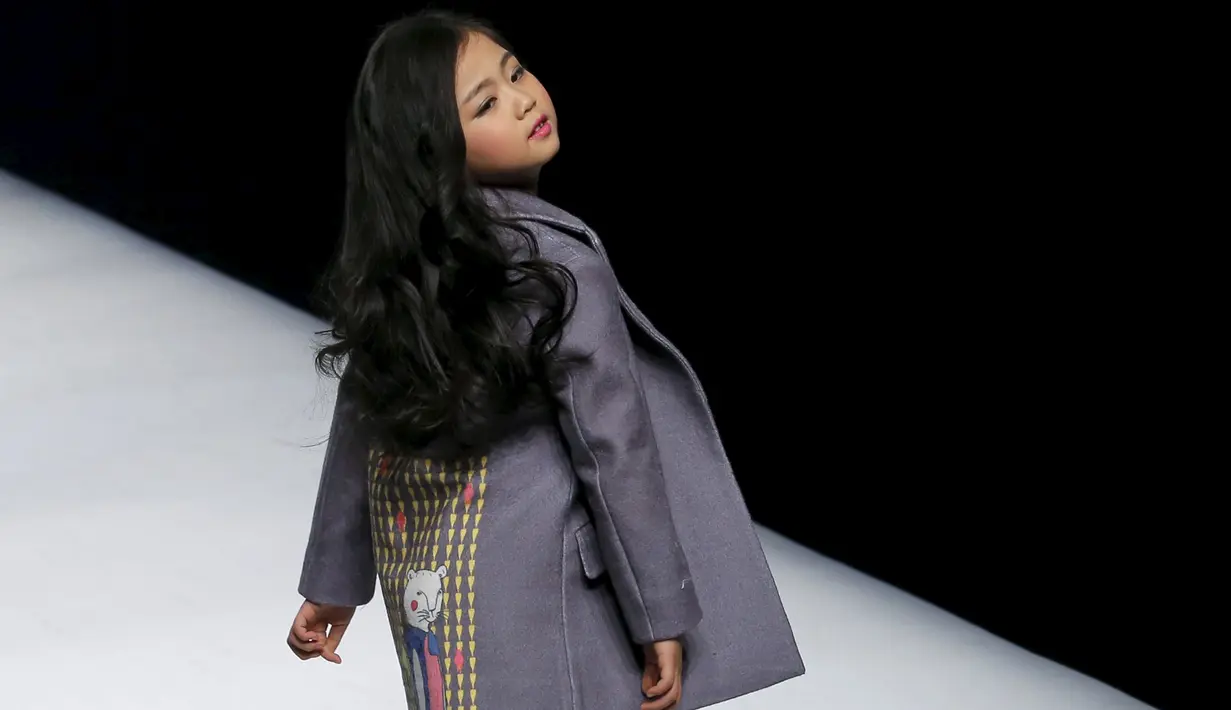 Seorang anak bergaya diatas catwalk mengenakan busana kreasi dari Ting Zu pada China Fashion Week,  Cina , (27/3). Busana kreasi Ting Zu ini memang diperuntukkan oleh anak-anak. (REUTERS / Kim Kyung - Hoon)
