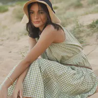 Duduk cantik di atas pasir pantai, Amanda Rawles terlihat cantik natural mengenakan dress piknik. Midi dress kotak-kotak berwarna hijau-putih, tanpa lengan ini terasa sangat pas dengan latar Amanda Rawless yang sedang main di alam. Ia menambahkan topi jerami yang manis sebagai aksesori kepala. Foto: Instagram.
