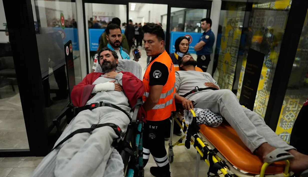 Para aktivis kemanusiaan Global Sumud Flotilla (GSF) diangkut dengan tandu beroda saat tiba di Bandara Istanbul, Turki, Kamis 21 Mei 2026. (AP Photo/Emrah Gurel)