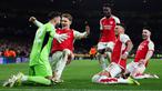 Pemain Arsenal merayakan kemenangan setelah David Raya berhasil menepis dua tendangan penalti dari pemain Porto pada laga leg kedua 16 besar Liga Champions 2023/2024 di Emirates Stadium, London, Inggris, Rabu (13/03/2024). (AFP/Adrian Dennis)