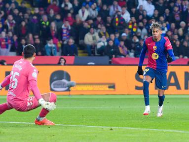 Pemain Barcelona, Lamine Yamal, mencetak gol ke gawang Real Betis pada laga babak 16 besar Copa del Rey 2024/2025 yang dihelat di Estadi Olimpic Lluis Companys, Kamis (16/1/2025) dini hari WIB. (AFP/Manaure Quintero)