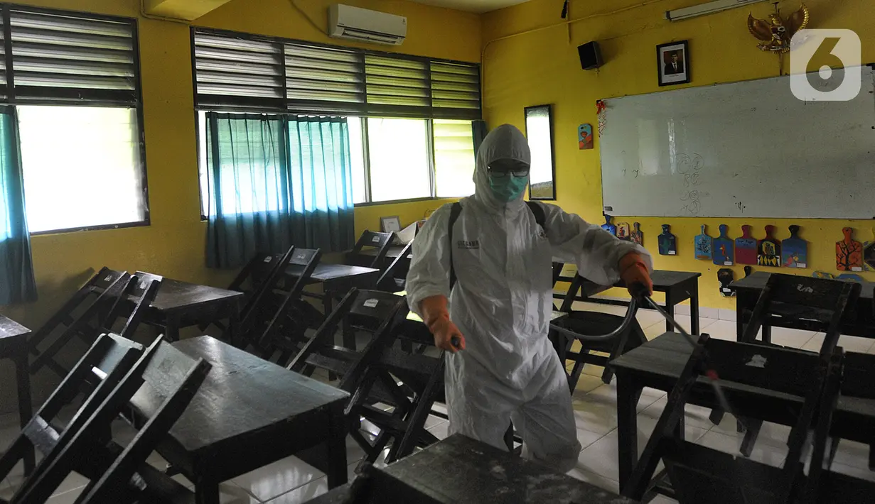 Petugas Palang Merah Indonesia (PMI) melakukan penyemprotan disinfektan di SMPN 216 Jakarta, Senin (16/3/2020). Mulai hari ini, aktivitas sekolah di sejumlah wilayah Indonesia diliburkan untuk mengantisipasi penyebaran virus corona COVID-19. (merdeka.com/Arie Basuki)