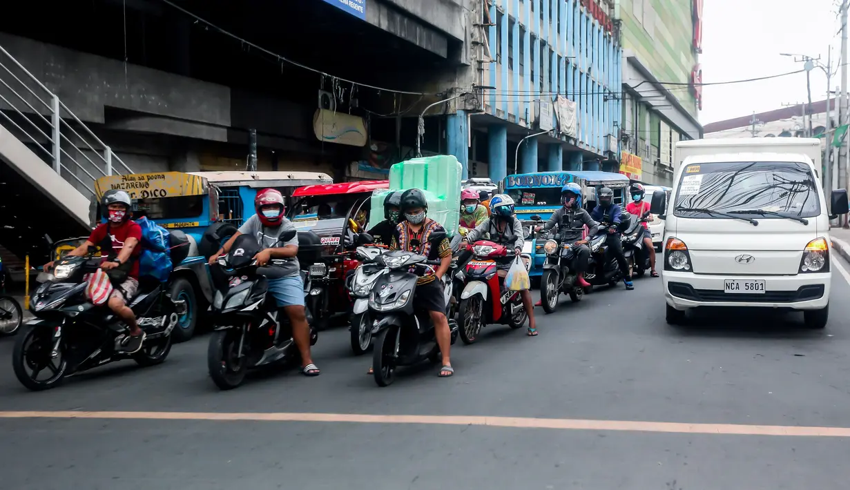 Pengendara motor mengenakan masker di Manila, Filipina (2/8/2020). Departemen Kesehatan negara itu melaporkan total 5.032 kasus baru Covid-19 pada Minggu (2/8) tersebut merupakan rekor kasus harian tertinggi selama empat hari berturut-turut. (Xinhua/Rouelle Umali)