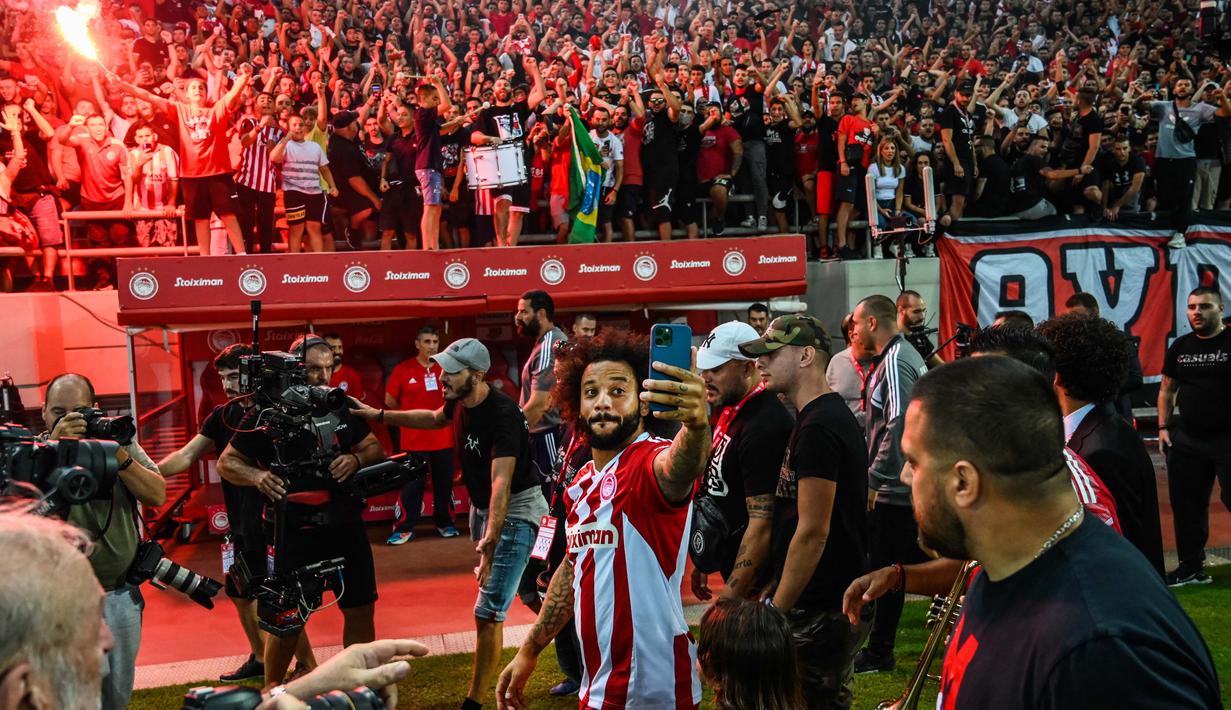 Suporter Olympiakos Piraeus menyambut gembira kedatangan Marcelo Vieira, mantan kapten Real Madrid. Tidak kurang dari 20.000 pendukung Olympiakos menyambut bintang asal Brasil saat memasuki stadion. (AFP/Angelos Tzortzinis)