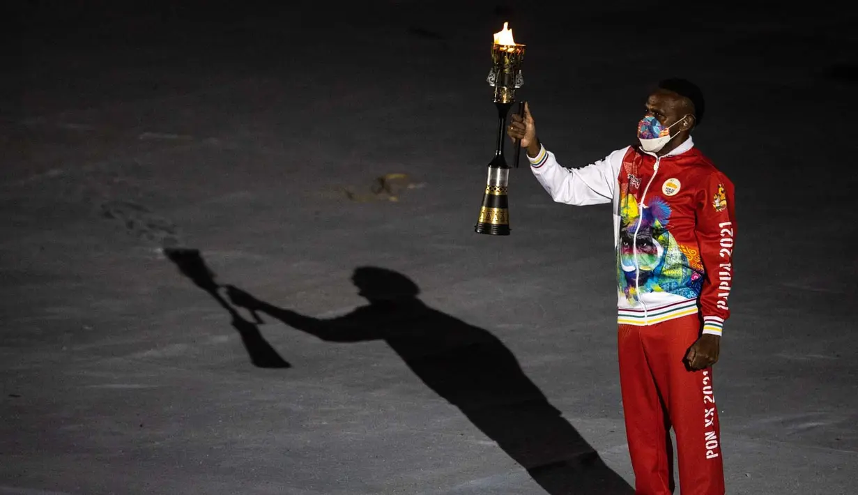 Boaz Solossa membawa obor api PON XX Papua 2021 pada acara Opening Ceremony di Stadion Utama Lukas Enembe, Kampung Harapan,Sentani, Kabupaten Jayapura, Sabtu (2/10/2021). (PB PON XX PAPUA/Robertus Pudyanto)