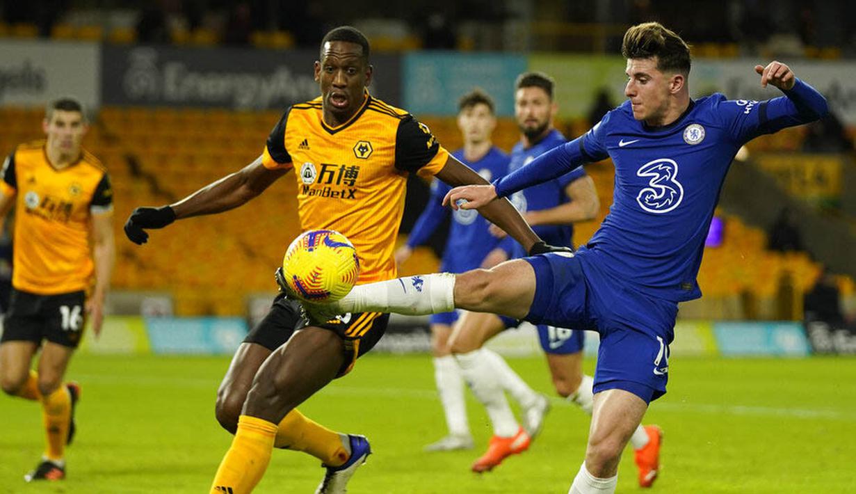 Pemain Wolverhampton Wanderers, Willy Boly, berebut bola dengan bek Chelsea, Mason Mount, pada laga Liga Inggris di Stadion Molineux, Rabu (16/12/2020). Chelsea tumbang dengan skor 2-1. (Tim Keeton/Pool via AP)