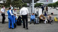 Penumpang dan staf maskapai menunggu di luar Bandara Toulouse-Blagnac di Blagnac, barat daya Prancis, pada 18 Oktober 2023, setelah bandara dievakuasi. Enam bandara di seluruh Prancis dievakuasi pada 18 Oktober 2023 setelah menerima email berisi "ancaman serangan", kata sumber polisi kepada AFP. (CHARLY TRIBALLEAU / AFP)