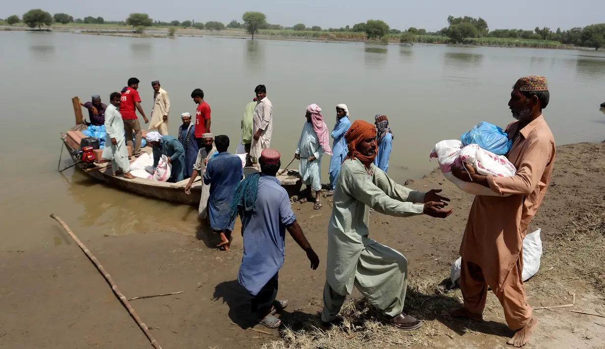 Korban banjir saat menerima bantuan Yayasan Edhi di Distrik Ghotki, Sindh Pakistan, Rabu (7/9/2022). Akses ke air bersih adalah masalah terbesar bagi mereka yang mencoba mencari makanan dan tempat tinggal. (AP Photo/Fareed Khan)