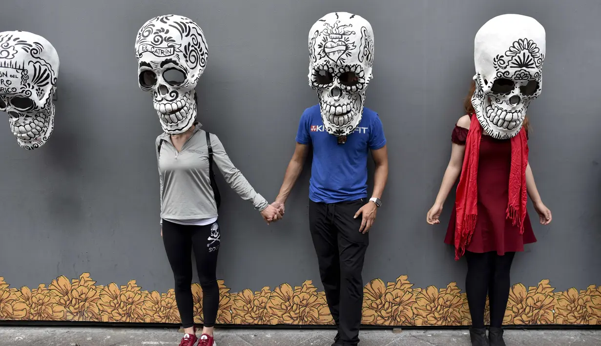 Sejumlah orang berfoto dengan replika tengkorak saat pameran dan kontes di perayaan Hari Kematian di Mexico City (1/11). Di Meksiko ada Festival El Dia de Los Muertos atau hari orang mati yang digelar setiap tahunnya. (AFP Photo/Yuri Cortez)