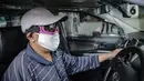 Pengemudi taksi daring, Aris Hardy Halim menunggu calon penumpang di dalam mobilnya yang telah terpasang plastik pembatas di kawasan Bendungan Hilir, Jakarta, Jumat (8/5/2020). (Liputan6.com/Faizal Fanani)