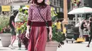 Julie Estelle mengenakan sweater turtleneck bermotif bunga dipadukan dengan rok berwarna merah yang manis dari Kate Spade. (Liputan6.com/IG/@julstelle)