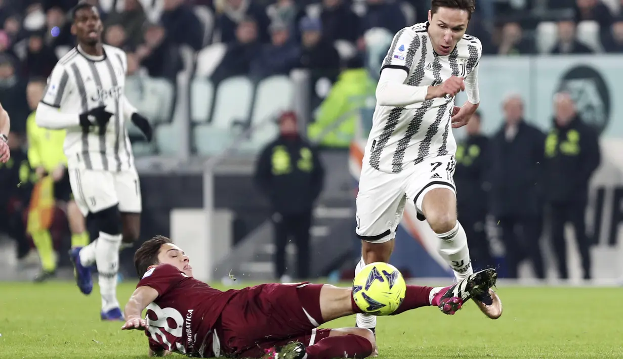 Penyerang Juventus Federico Chiesa mencoba menghindari tantangan meluncur dari gelandang Torino Samuele Ricci pada pekan ke-24 Liga Italia di Stadion Allianz, Rabu (1/3/2023) dini hari WIB. Empat gol I Bianconeri dilesakkan oleh Juan Cuadrado, Danilo, Gleison Bremer, Adrien Rabiot . (Tano Pecoraro/LaPresse via AP)