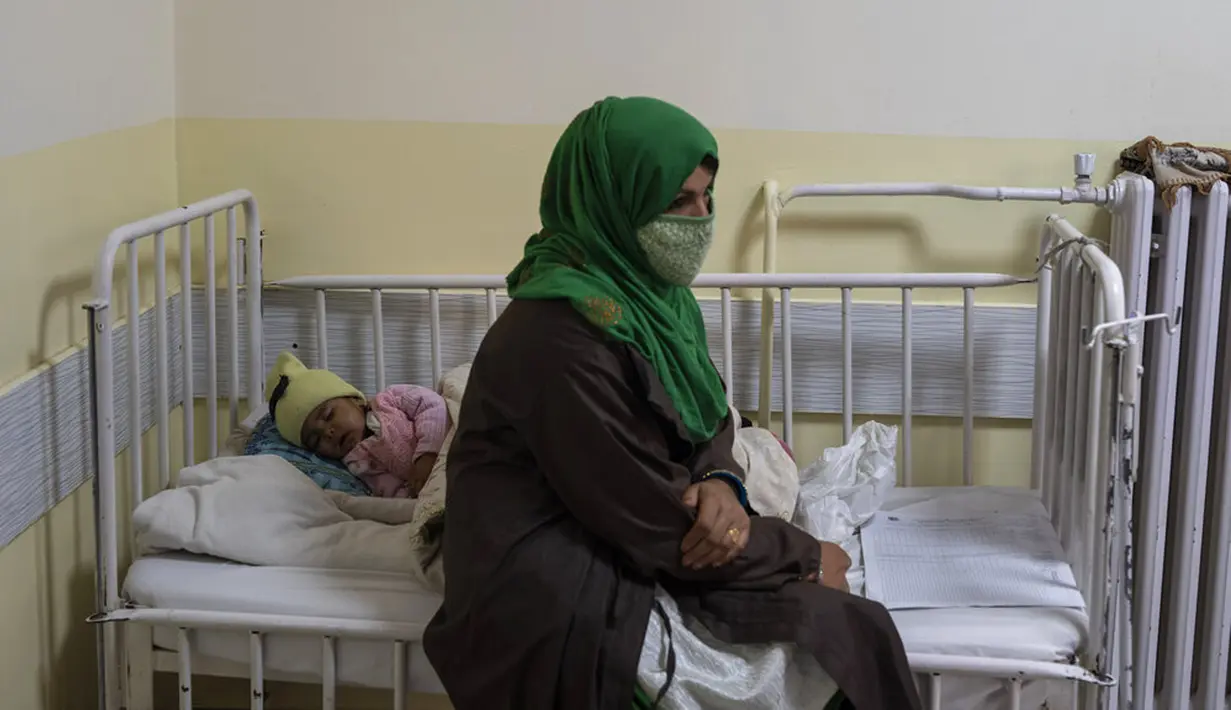 Seorang bayi perempuan tidur di tempat tidur di samping ibunya saat menjalani perawatan di bangsal gizi buruk RS Anak Nasional Ataturk, Kabul, Afghanistan, 2 Desember 2021. Peningkatan jumlah anak gizi buruk telah memenuhi bangsal rumah sakit di Afghanistan. (AP Photo/Petros Giannakouris)