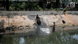 Sejumlah anak-anak berenang di kali menteng, Jakarta, Selasa (20/8/2019). Kurangnya lahan bermain membuat mereka terpaksa memanfaatkan kali menteng yang kotor sebagai tempat bermain. (Liputan6.com/Faizal Fanani)