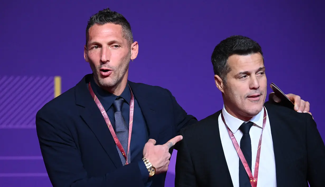Mantan pesepak bola Italia dan pemenang piala dunia Marco Materazzi (kiri) dan mantan pesepak bola Brasil Julio Cesar (kanan) tiba untuk menghadiri undian atau drawing Piala Dunia 2022 Qatar di Doha Exhibition and Convention Center pada 1 April 2022. (FRANCK FIFE / AFP)