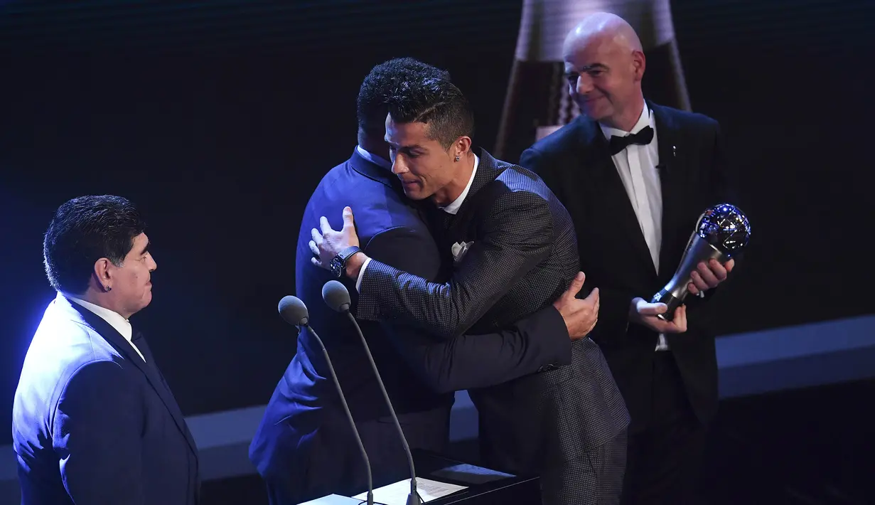 Bintang Real Madrid, Cristiano Ronaldo,memeluk Ronaldo saat menerima trofi pemain terbaik FIFA 2017 di London, Senin (23/10/2017) Ronaldo berhasil mengalahkan Lionel Messi dan Neymar yang juga menjadi nominasi. (AFP/Ben Stansall)