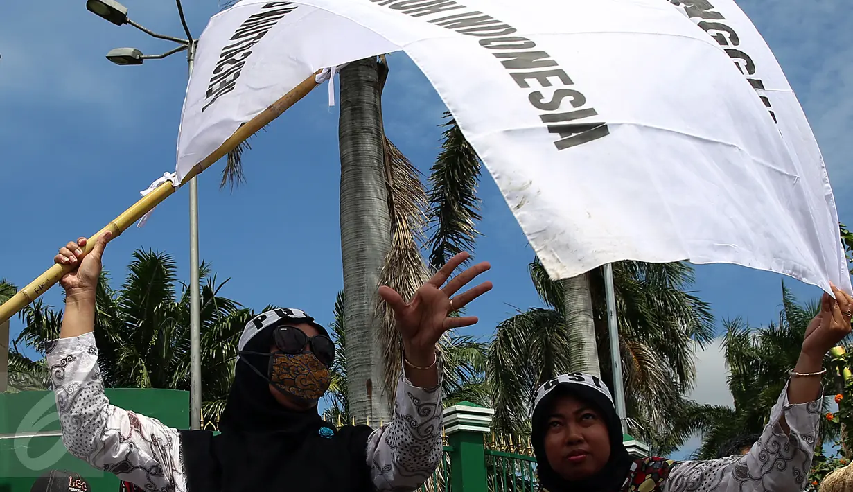 Dua guru membentangkan bendera saat unjuk rasa di depan Gedung DPR/MPR, Jakarta, Kamis (12/1). Mereka juga menuntut tunjangan sertifikasi bagi guru agama yang bernaung di Kemenag yang hingga kini belum terbayar. (Liputan6.com/Johan Tallo)
